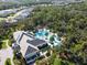 Aerial view of community pool area surrounded by lush trees, palms and lounge chairs, a perfect oasis at 12408 Palatka Dr, Venice, FL 34293