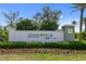 A Grand Palm by Neal Communities sign is displayed with colorful flowers in front of the community at 12408 Palatka Dr, Venice, FL 34293