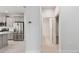 Hallway view of stainless steel refrigerator and kitchen with a view into the bathroom at 12408 Palatka Dr, Venice, FL 34293