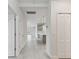 Bright hallway featuring neutral tones and tile floors, leading to the kitchen and living spaces at 12408 Palatka Dr, Venice, FL 34293