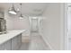 Hallway view with gray tile flooring, quartz countertop, and stylish pendant lights at 12408 Palatka Dr, Venice, FL 34293
