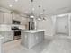 A modern kitchen features gray cabinets, stainless steel appliances, and an island with quartz countertops at 12408 Palatka Dr, Venice, FL 34293