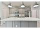 Spacious kitchen with gray cabinets, stainless steel appliances, and a center island with pendant lights at 12408 Palatka Dr, Venice, FL 34293