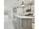Modern kitchen with gray cabinets, stainless steel appliances, and a large center island at 12408 Palatka Dr, Venice, FL 34293