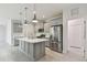 Open kitchen with a large island, pendant lighting, and stainless steel appliances at 12408 Palatka Dr, Venice, FL 34293
