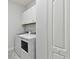 Convenient laundry area features white appliances and ample storage cabinets for supplies at 12408 Palatka Dr, Venice, FL 34293