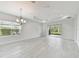 An open living area with large windows and doors leading to the screened lanai at 12408 Palatka Dr, Venice, FL 34293