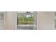 View of a serene pond and screened in patio from inside the property at 12408 Palatka Dr, Venice, FL 34293