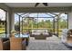 Beautiful screened patio with pond view features outdoor seating, dining table, and grill at 12408 Palatka Dr, Venice, FL 34293