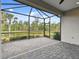 An empty screened-in patio features a beautiful view of the nearby pond and landscaping at 12408 Palatka Dr, Venice, FL 34293