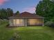 Beautiful backyard view of home with lush green lawn, landscaping and screened-in patio at 14198 Thoroughbred Dr, Dade City, FL 33525