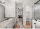 Bright bathroom featuring double sinks, decorative lights, granite countertops, and a walk-in shower at 14198 Thoroughbred Dr, Dade City, FL 33525