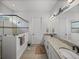 Bright bathroom featuring double sinks, granite countertops, and a glass-enclosed shower at 14198 Thoroughbred Dr, Dade City, FL 33525