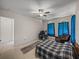 Bedroom with tile flooring, white walls, ceiling fan and blue curtains at 14198 Thoroughbred Dr, Dade City, FL 33525