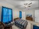 This bright bedroom features light walls, TV and ceiling fan at 14198 Thoroughbred Dr, Dade City, FL 33525