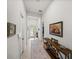 Bright hallway featuring decorative artwork, a console table, and a glimpse of the front door at 14198 Thoroughbred Dr, Dade City, FL 33525