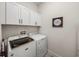 Laundry room with white cabinets and side-by-side washer and dryer at 14198 Thoroughbred Dr, Dade City, FL 33525