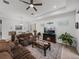 Comfortable living room features a ceiling fan, fireplace, and large television at 14198 Thoroughbred Dr, Dade City, FL 33525