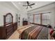 Inviting main bedroom featuring tray ceilings, fan, dresser, and well-lit windows at 14198 Thoroughbred Dr, Dade City, FL 33525