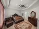 Spacious main bedroom with tray ceilings, a fan, a seating area, and a luxurious dresser at 14198 Thoroughbred Dr, Dade City, FL 33525