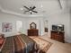 Well-lit main bedroom showcasing tray ceilings, a modern ceiling fan, and furniture at 14198 Thoroughbred Dr, Dade City, FL 33525