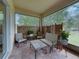Inviting screened patio featuring brick flooring, comfortable seating, and a tranquil view of the surrounding landscape at 14198 Thoroughbred Dr, Dade City, FL 33525