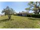 Spacious backyard featuring a well-maintained lawn and a glimpse of the screened-in patio at 14296 Pullman Dr, Spring Hill, FL 34609