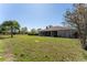 Lush backyard featuring a screened-in lanai, mature landscaping, and a well-maintained lawn at 14296 Pullman Dr, Spring Hill, FL 34609
