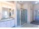 Bathroom vanity with a large mirror, enclosed shower and open access to the bedroom at 14296 Pullman Dr, Spring Hill, FL 34609