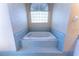 Soaking bathtub with glass block window and tiled surround at 14296 Pullman Dr, Spring Hill, FL 34609
