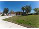 Charming single-story home with a three-car garage and mature landscaping, set against a blue sky at 14296 Pullman Dr, Spring Hill, FL 34609