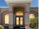 Close-up of the front entrance with a decorative transom window and stylish double doors at 14296 Pullman Dr, Spring Hill, FL 34609