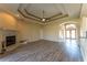 Spacious living room with a cozy fireplace, tray ceiling, and beautiful floors at 14296 Pullman Dr, Spring Hill, FL 34609