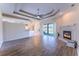 Open-concept living room with wood flooring, tray ceilings, and a cozy fireplace at 14296 Pullman Dr, Spring Hill, FL 34609
