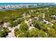 An aerial view of the property surrounded by lush greenery with views of the bay and city at 14323 83Rd Pl, Seminole, FL 33776