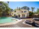 A backyard pool with lounge chairs and a hot tub on a wooden deck at 14323 83Rd Pl, Seminole, FL 33776