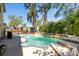 A backyard with a freeform pool with a stone waterfall and integrated steps at 14323 83Rd Pl, Seminole, FL 33776