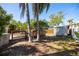 A backyard shed with a wooden deck, palm trees and lush landscaping at 14323 83Rd Pl, Seminole, FL 33776