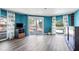 Bright living room with wood floors and access to an outdoor deck and pool at 14323 83Rd Pl, Seminole, FL 33776