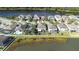 An aerial view of homes in a community near a picturesque lake, featuring fenced yards and screened patios at 1564 Imperial Key Dr, Trinity, FL 34655