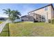 Spacious backyard featuring a screened-in patio, lush grass, and a white picket fence at 1564 Imperial Key Dr, Trinity, FL 34655
