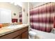 Well-lit bathroom featuring a vanity with a sink, a toilet, and a shower-tub combination with curtain at 1564 Imperial Key Dr, Trinity, FL 34655