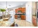 Well-lit kitchen featuring granite countertops, a stainless sink, and wooden cabinetry at 1564 Imperial Key Dr, Trinity, FL 34655