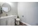 Updated half bathroom features a modern sink and vanity with storage and a round mirror at 161 Brightwater Dr # 8, Clearwater Beach, FL 33767