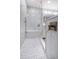 The bathroom has a glass enclosed shower featuring elegant tile, a built in seat and modern fixtures at 161 Brightwater Dr # 8, Clearwater Beach, FL 33767