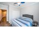 Bedroom featuring blue striped comforter, ceiling fan, closet and wood-look flooring at 161 Brightwater Dr # 8, Clearwater Beach, FL 33767