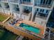 Aerial view of a backyard featuring a rectangular pool, brick patio, outdoor seating, and access to a dock and waterway at 161 Brightwater Dr # 8, Clearwater Beach, FL 33767