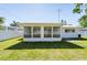 Wide view of a backyard featuring well-kept lawn and a screened-in patio at 2019 Inner S Cir, St Petersburg, FL 33712