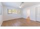Bright bedroom features wood-look flooring, ceiling fan, and a view into the bathroom at 2019 Inner S Cir, St Petersburg, FL 33712