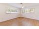 Bright bedroom features wood-look flooring, ceiling fan, and ample natural light from large windows at 2019 Inner S Cir, St Petersburg, FL 33712